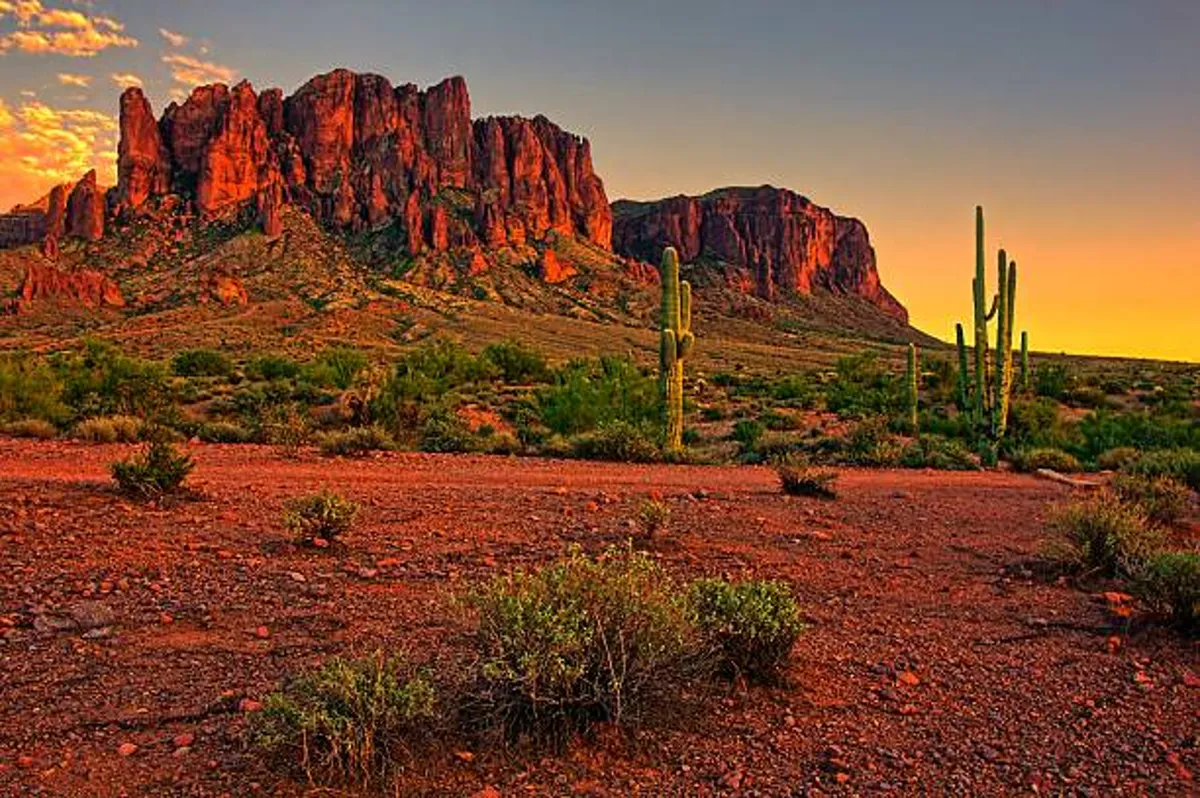 A sweeping view of a majestic mountain range with tall cacti in the foreground and a vibrant sunset sky overhead. The tranquil atmosphere captures the essence of the desert at dusk, offering a visual connection to the backyard sunset views mentioned in the section.
